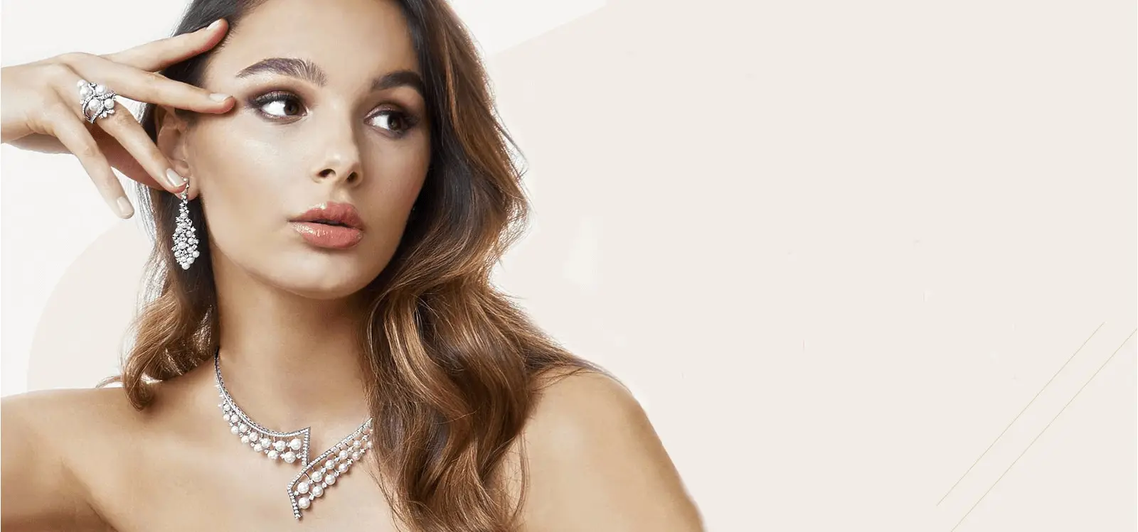 A woman with long brown hair wearing jewelry and looking stylish and glamorous.