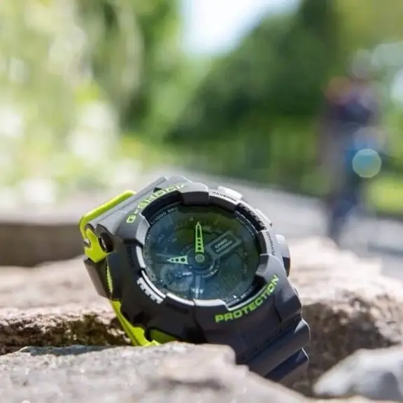 A black and green rugged watch with various buttons and dials